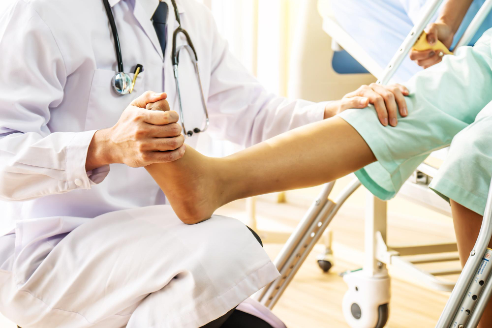 Médico examinando o pé e a perna de um paciente em ambiente clínico.